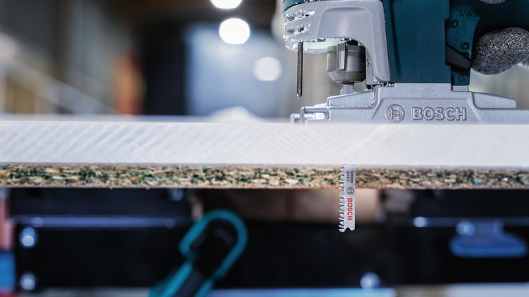 電動曲線鋸正在切割一塊層壓木材。