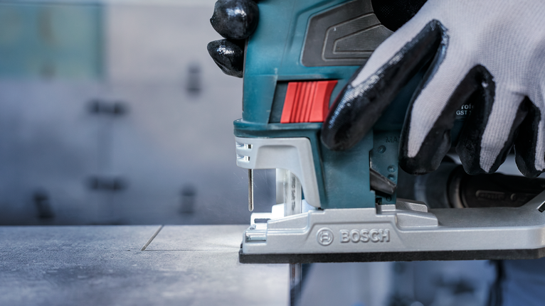 PRO Soft Tile T130RF 線鋸片,83 mm,3 件 配戴安全設備的人員使用曲線鋸在金屬板上切割出一條直線。