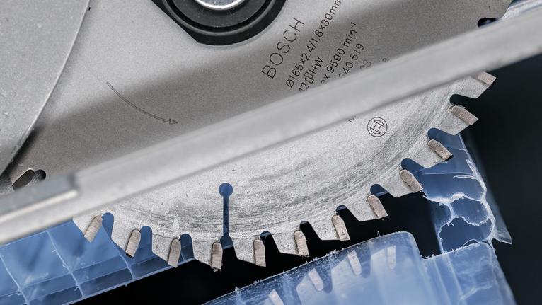 圓鋸片切割藍色塑膠材料。