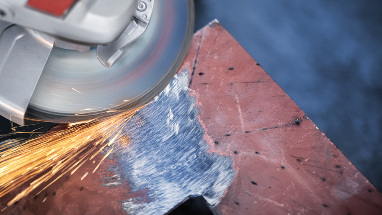 角磨機在打磨金屬板邊緣時產生火花。