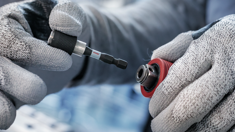 配戴安全設備的人員將螺絲起子頭插入鑽夾頭。