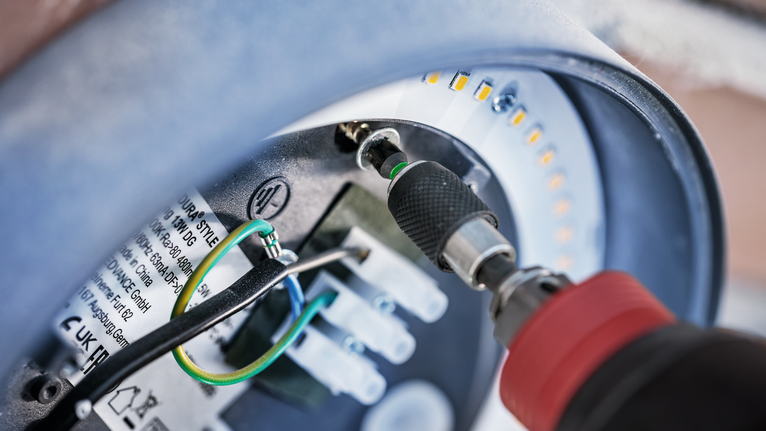 無線螺絲起子鎖緊圓形 LED 燈具內的螺絲。