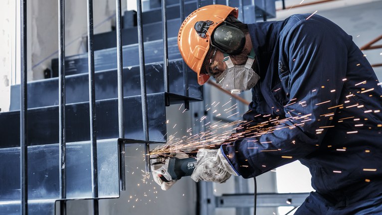 穿著安全設備的人磨擦金屬樓梯，向外發出火花。.