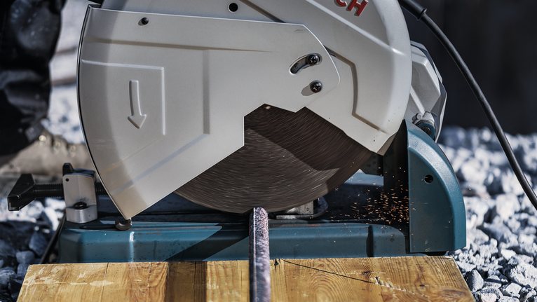 金屬切割鋸切割鋼筋，在木質表面產生火花。