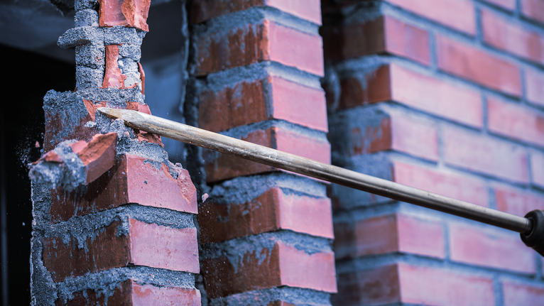 鑿子工具在建築工地上鑿碎紅磚。