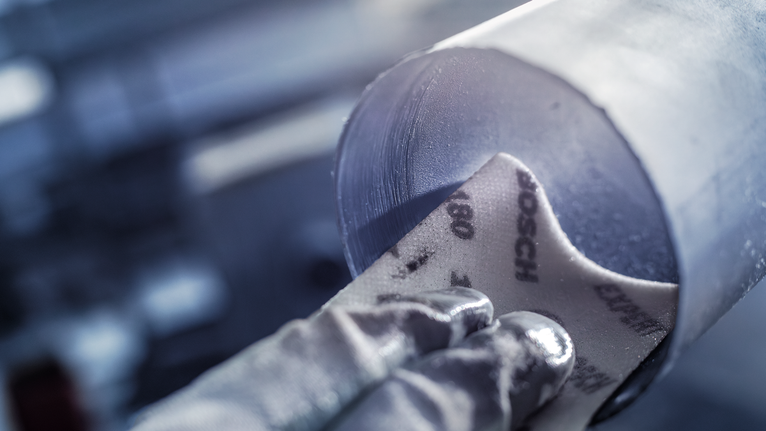 佩戴安全設備的人員正在打磨金屬管道內部。