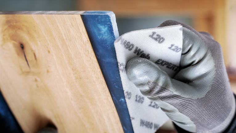 穿著安全設備的人員正在打磨木質表面。