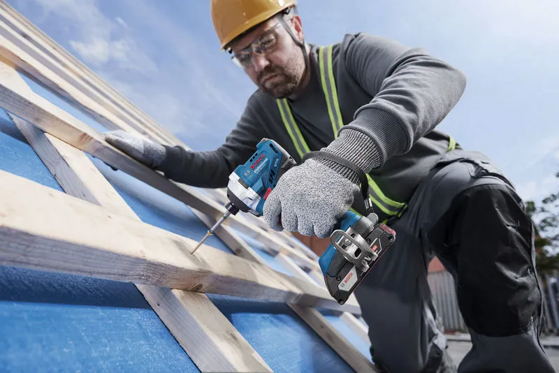 GDR 18V-215 一名配戴安全設備的人員使用無線電鑽將螺絲旋入木樑。.