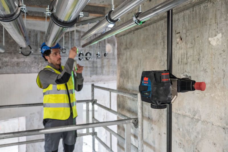 BT 350 一名配戴安全設備的人員使用雷射調平工具對準管道。.