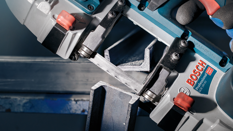 配戴安全設備的人員使用電鋸切割金屬樑。