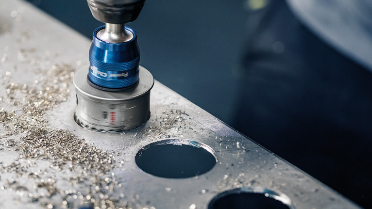 孔鋸在金屬板上鑽出乾淨的圓孔。