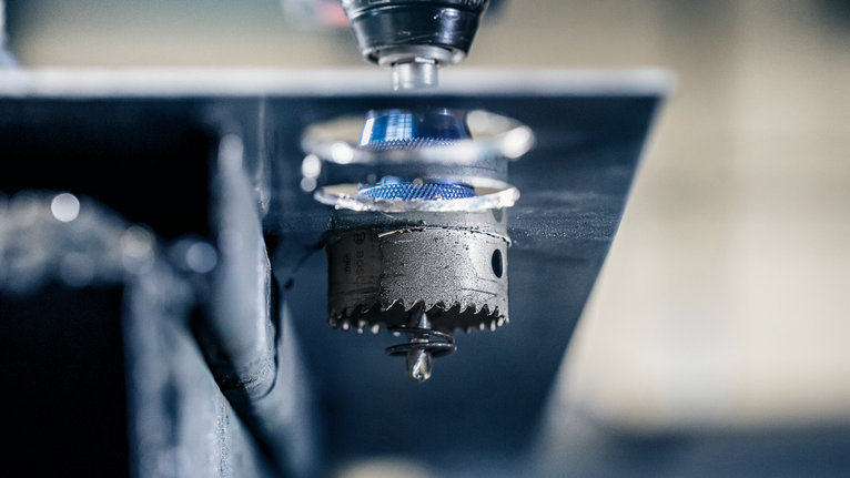 在工業環境中，孔鋸可以鑽穿金屬板。