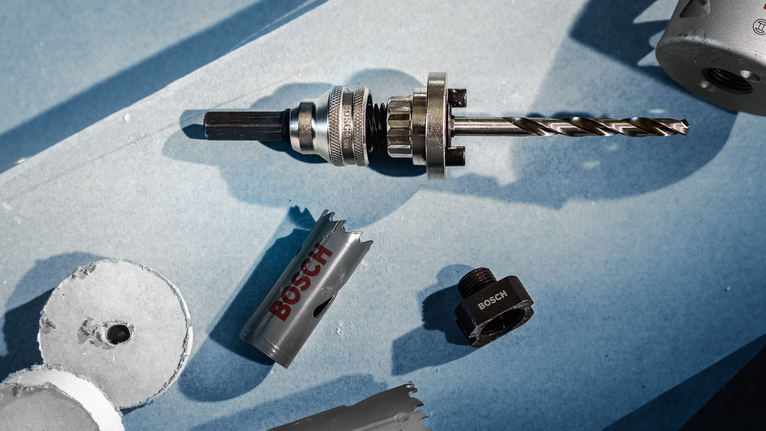 金屬鑽頭，帶有孔鋸附件和藍色表面上的切割圓盤。