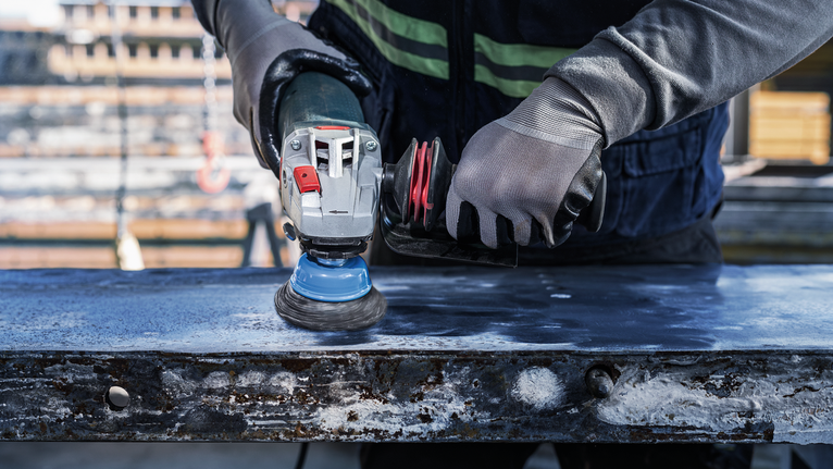 PRO Metal clean 碗形刷,75 x 0.3 mm,螺紋 配戴安全設備的人員使用角磨機拋光金屬表面。