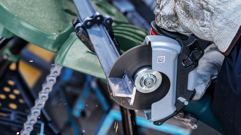 配戴安全設備的人員用圓鋸切割金屬管。