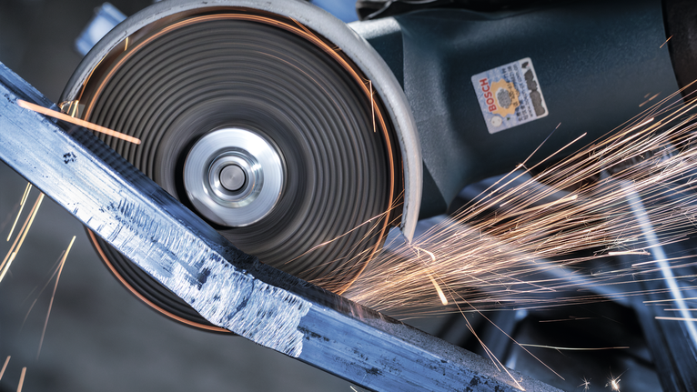 切削工具磨削金屬，產生明亮的火花。