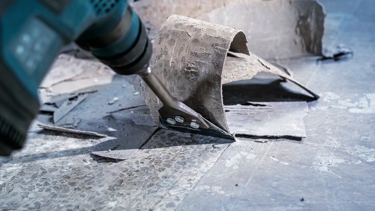 帶有鑿子附件的電動工具可從堅硬表面去除舊地板。