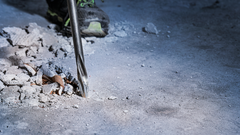 旋轉錘鑽破混凝土地板。