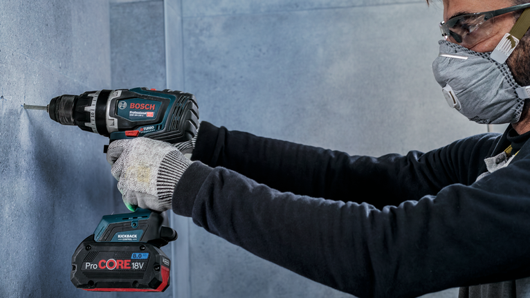 PRO Ceramic (乾式瓷磚用) 鑽頭套組,6 x 66,6 x 66,8 x 66 mm,3 件組 一名佩戴安全設備的人正在鑽入混凝土牆。