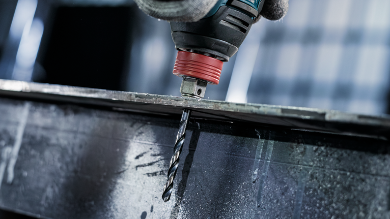 配戴安全設備的人員鑽穿金屬梁。