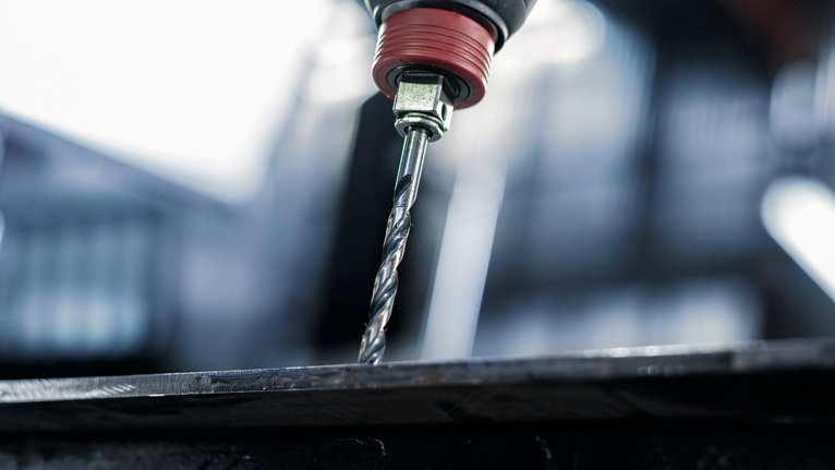 PRO Metal HSS-G Impact 抗衝擊金屬鑽頭套組,8 件 鑽頭在金屬板上鑽孔。