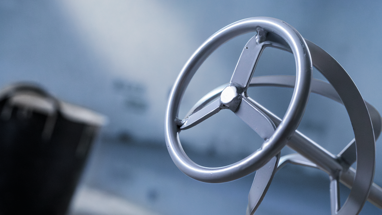 在模糊的藍色背景上顯示了電動工具的鋼製攪拌槳附件。