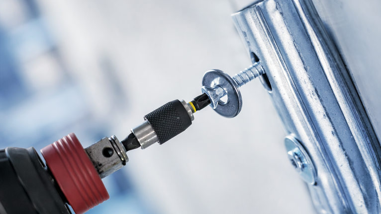 無線電鑽將螺絲旋入金屬支架。