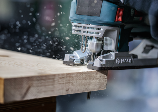 PRO Wood precise T144DP 線鋸片,100 mm,5 片 一名佩戴安全設備的人使用曲線鋸切割木板。