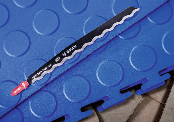 PRO Soft Material T313AW 線鋸片,152 mm,3 件 拼圖鋸刀片放置在互鎖的藍色泡沫地板上。