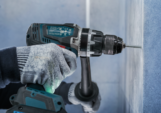 PRO Ceramic (乾式瓷磚用) 鑽頭套組,6 x 66,6 x 66,8 x 66 mm,3 件組 佩戴安全設備的人將螺絲鑽入牆壁。