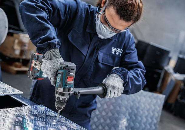 配戴安全設備的人員正在鑽金屬板。