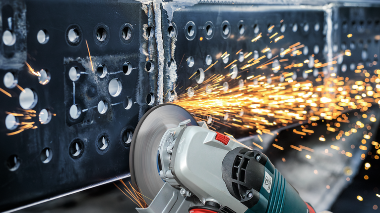 角磨機切割金屬梁時火花四濺。.