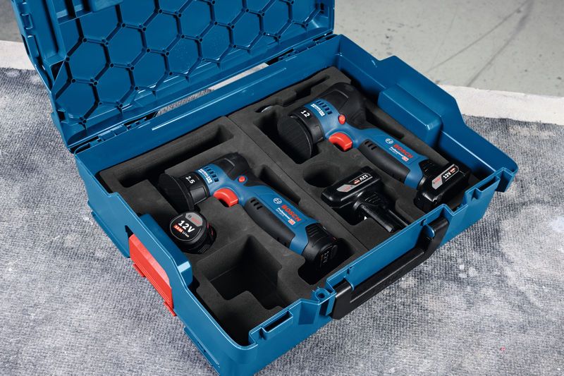 GEX 12V-77 無線電動工具和電池整齊地放在工作台上的藍色手提箱中。.
