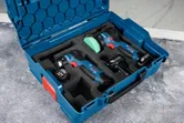 無線隨機軌道砂光機套裝，電池和充電器整齊地排列在藍色盒子中。