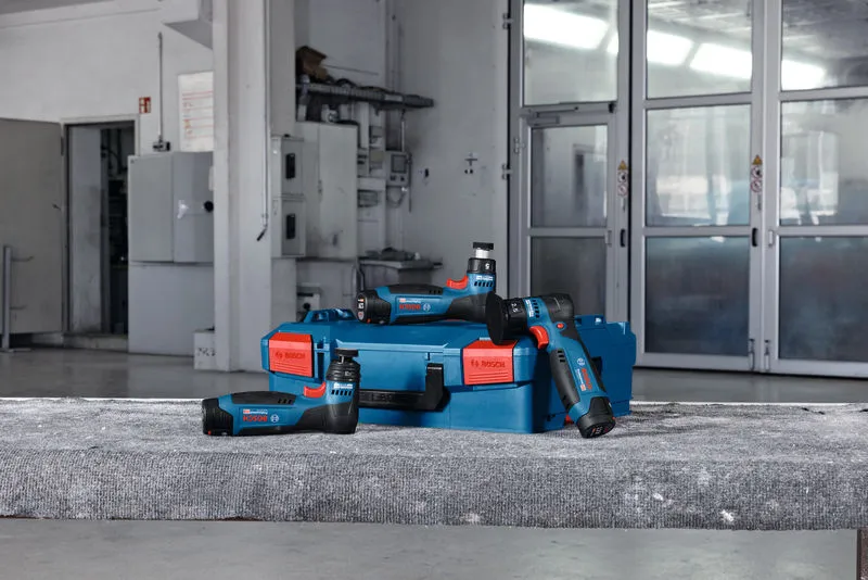 無線隨機軌道砂光機和藍色盒子放置在車間的混凝土表面上。.