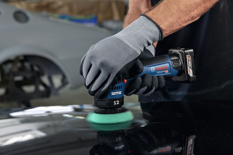 GPX 12V-77 一名佩戴安全設備的人正在使用無線拋光機拋光汽車錶面。.