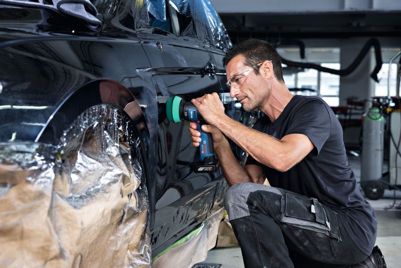 GPX 12V-77 一名配戴安全設備的人員正在使用無線工具擦拭車門。.