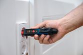 一個人在電源插座附近使用非接觸式電壓測試器。