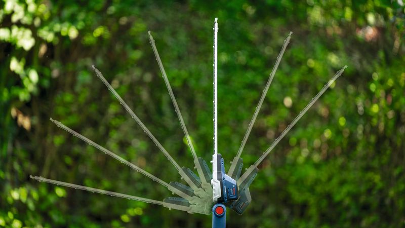 無線伸縮式樹籬修剪機，可在戶外調整切割角度。.