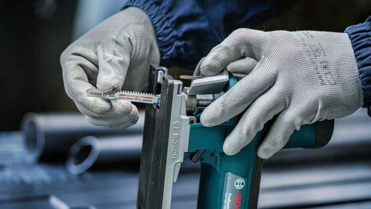 超耐久超厚金屬專業款 T155HHM 線鋸片,3 件 配戴安全設備的人員將鋸片插入電動工具。