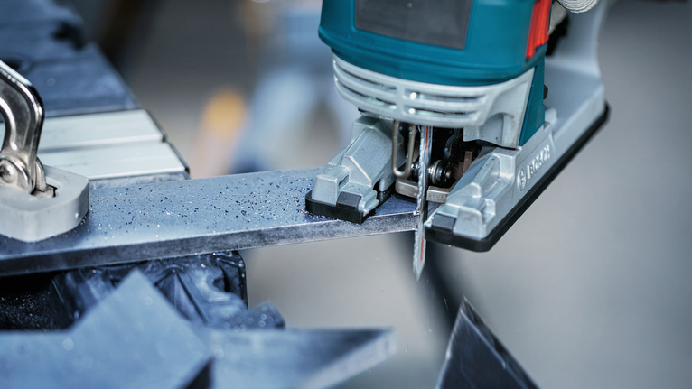 超耐久超厚金屬專業款 T155HHM 線鋸片,3 件 車間裡,拼圖鋸正在切割金屬棒。