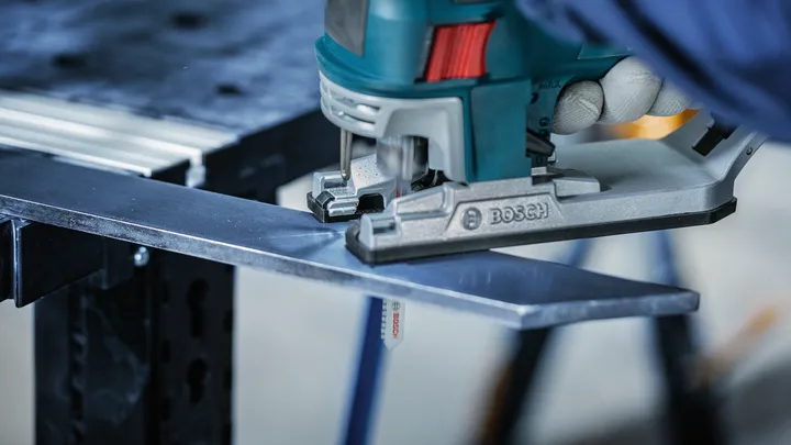 Object #200559119: 7478951_app_web_09 配戴安全設備的人用曲線鋸切割金屬板。