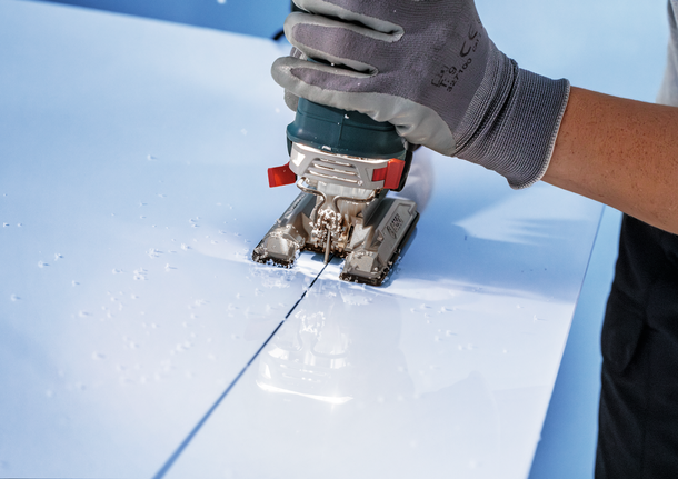 PRO Plastics PP 細緻切割款 T102D 線鋸片,100 mm,2 件 工人穿著安全裝備,用曲線鋸在白色面板上切割一條直線。.