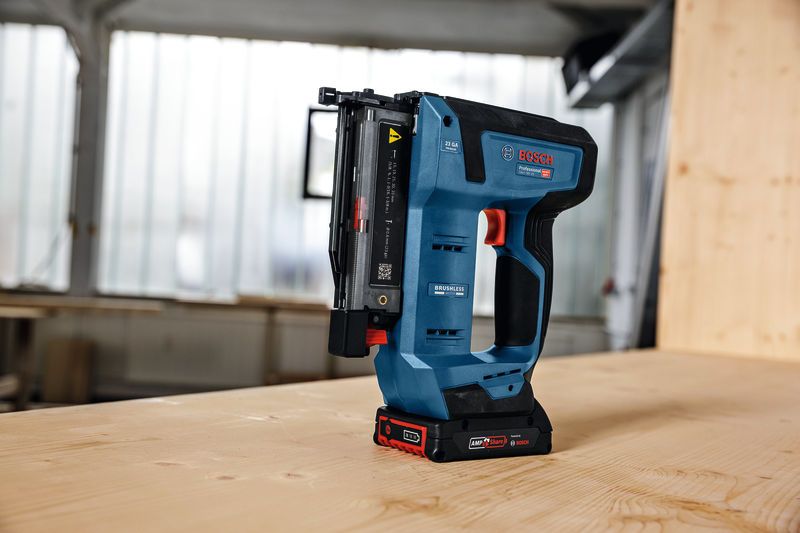 無線釘槍直立在車間的木桌上。.