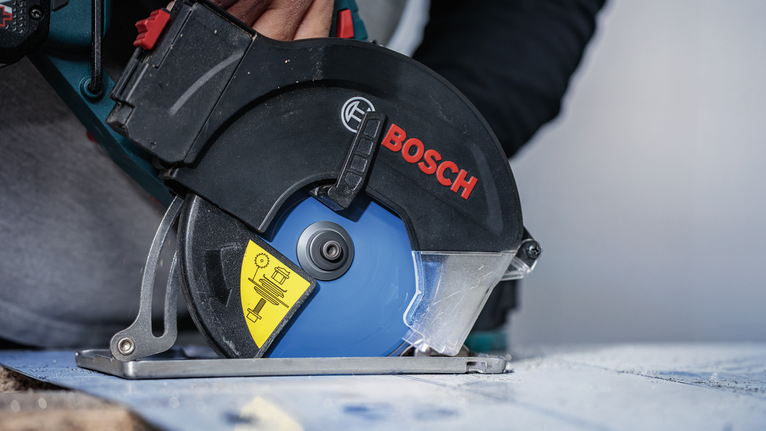 配戴安全設備的人員使用圓鋸切割木材。.