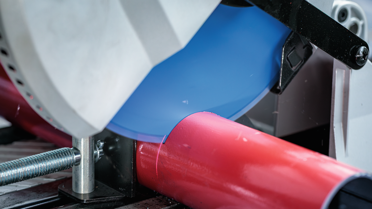 EXPERT Steel 鋼材圓鋸片,305 x 2.6/2.2 x 25.4 mm,T80 金屬切割鋸切割固定在夾具中的紅色管道。.