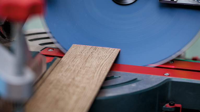 圓鋸在斜切鋸工作站上切割木板。.