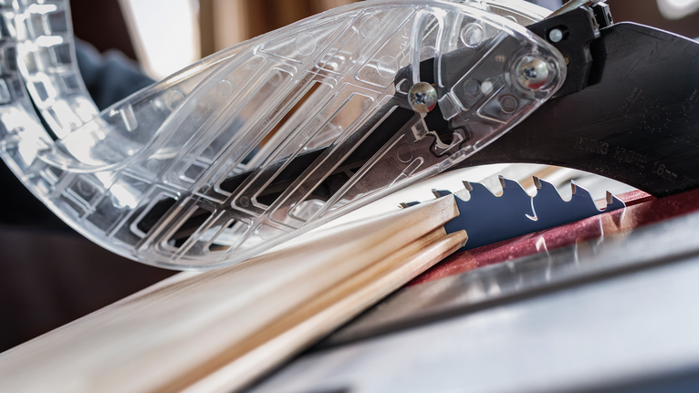 圓鋸切割木板，附有保護刀片的防護罩。.