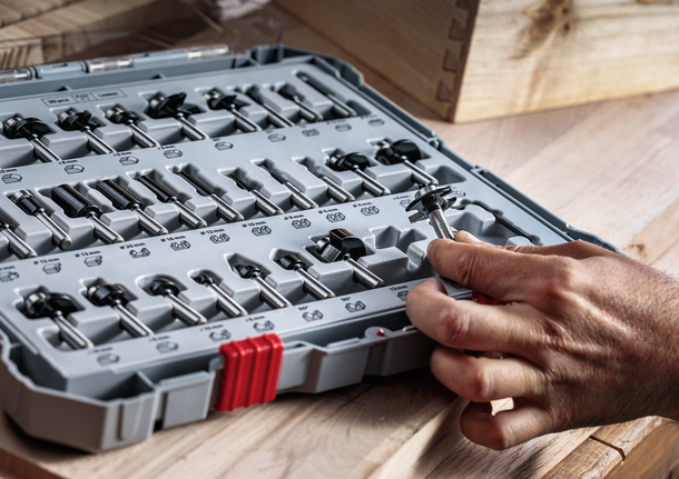 人們在木製工作台上從整齊排列的鑽頭中挑選鑽頭。.