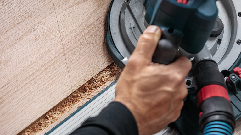 人們操作圓鋸沿直線切割木材。.